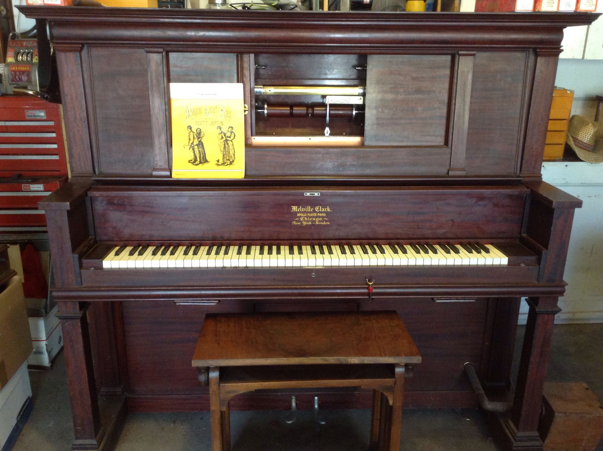Melville Clark player piano in good working condition, Circa late 1800s With lots of rolls, The player works and bellows have been rebuilt.