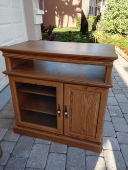 Classic oak color entertainment center. Open component 2 adjustable shelves. 2 fold out storage shelves behind door. Excellent condition. 34H 37W