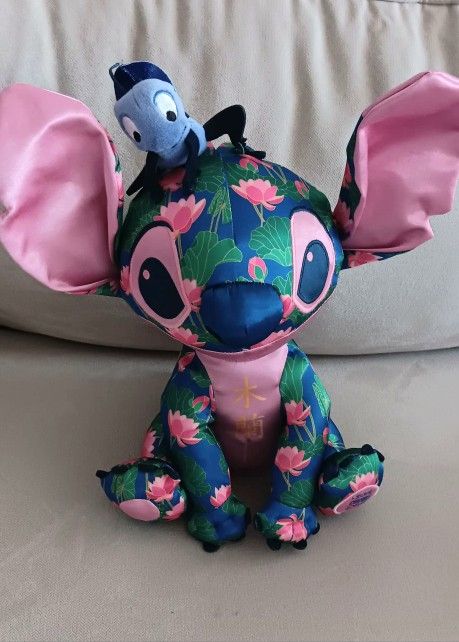 Disney Authentic Stitch Crashes Plush Mulan. Measures about 12 inches tall, not including Cri-Kee. Beautiful lotus flower pattern, Mulan written in C