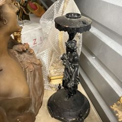 A cast metal Art Nouveau female figure candlestick holder. Candlestick holders have been used for centuries to provide light and enhance ambiance in h