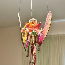 *Whimsical handcrafted decorative fairy w/ bicycle mobile. hanging fairy doll w/ bright yellow hair, wearing a crown, and riding a bicycle that has la