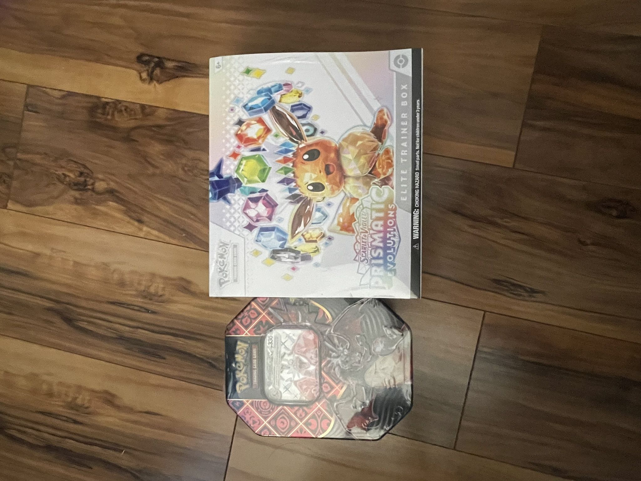 Prismatic Elite Trainer Box And Paldean Fates Charizard Tin