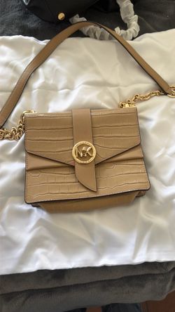 This is a Michael Kors Greenwich crossbody bag featuring a tan, crocodile-embossed design and a gold-tone chain strap.