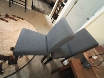 A pair of grey fabric dining chairs