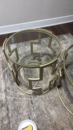 Different sizes of gold colored glass tables