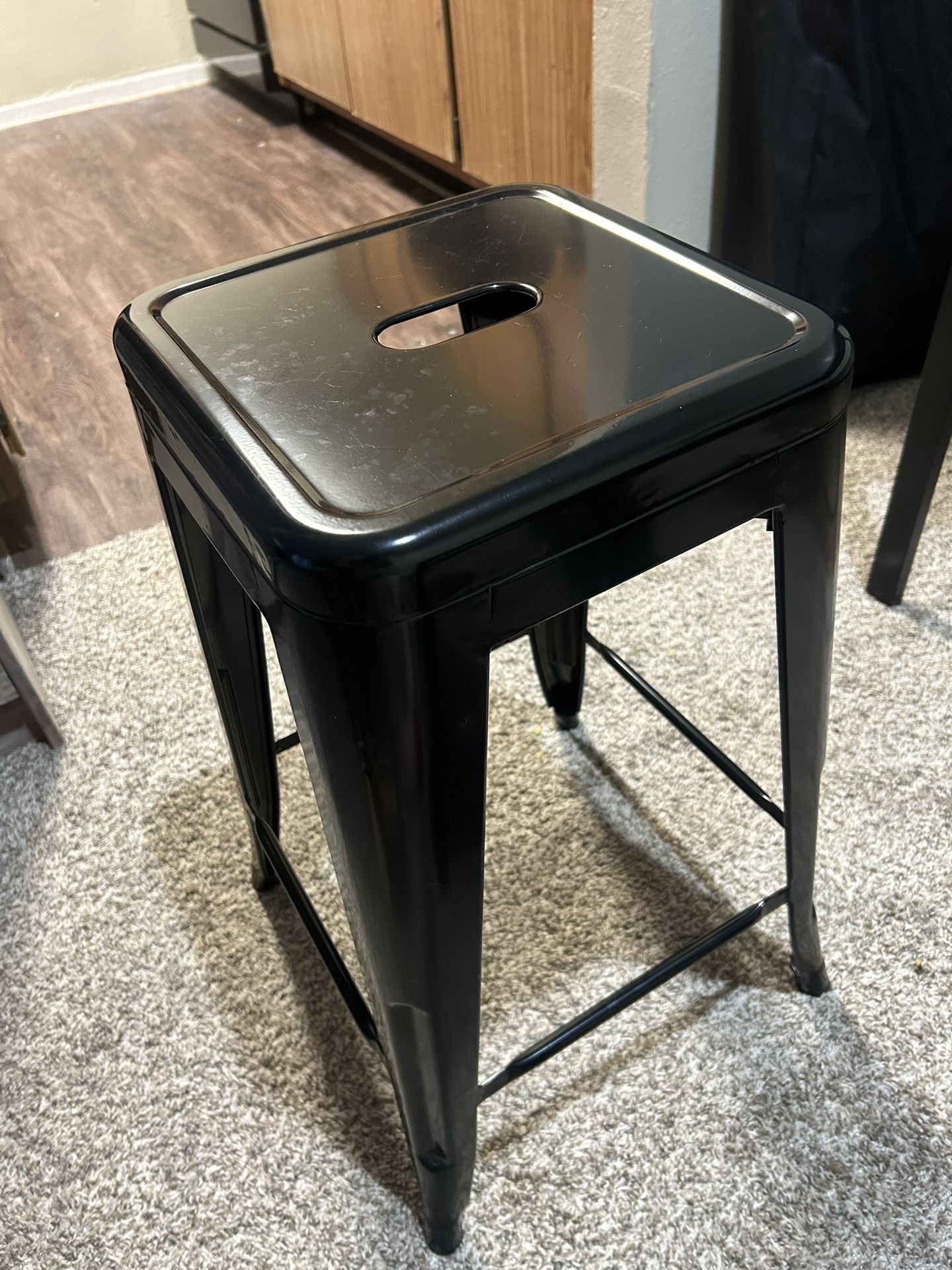 Small dining table with two black industrial stools 