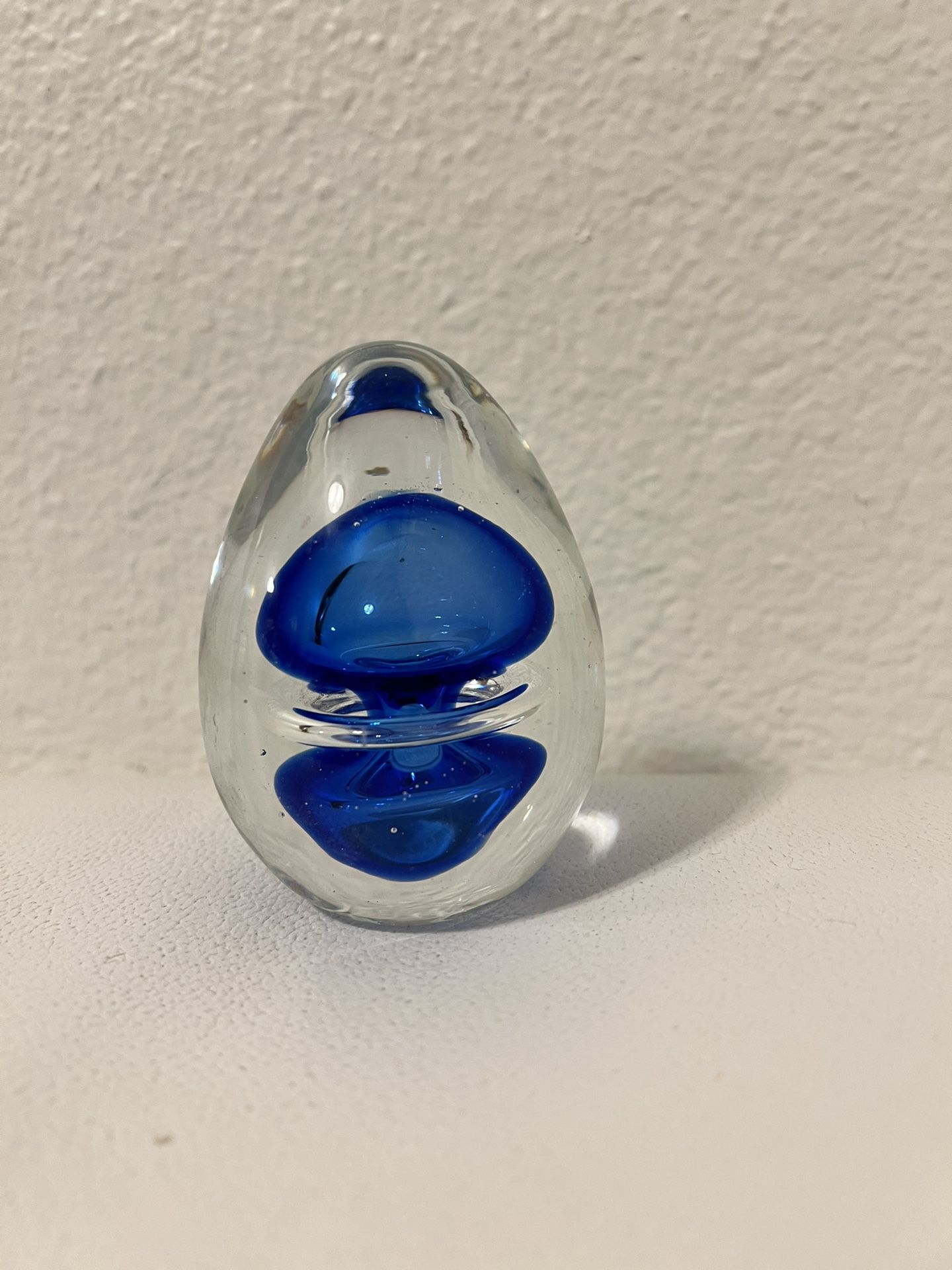 vintage art glass paperweight in the shape of an egg, clear blue bubbles, ocean