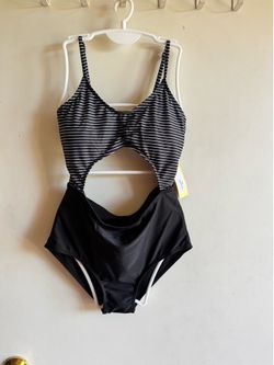 Chic black and white one-piece with a fashionable midriff cutout. Soft, stretchy fabric offers comfortable wear for pool and beach days. Adjustable sh