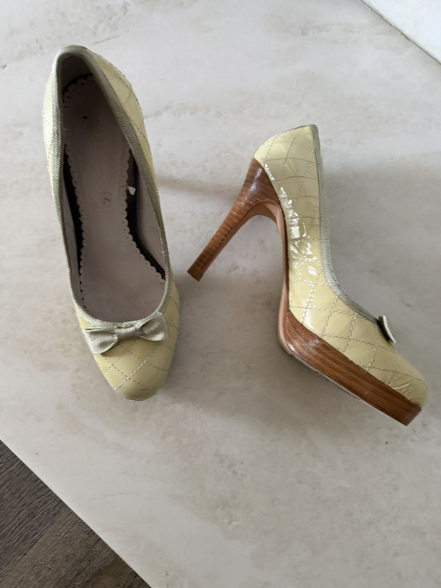 Chic yellow heels with quilted design. Adorned with a cute bow. Perfect for stylish outings.