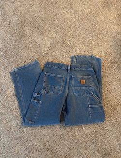 vintage Carhartt B13 DST dungaree denim jeans featuring a distressed blue wash and a wide-leg cut.