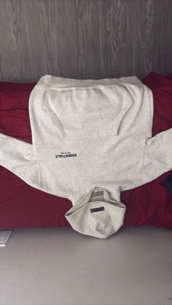 This is a Fear of God Essentials Light Oatmeal hoodie.