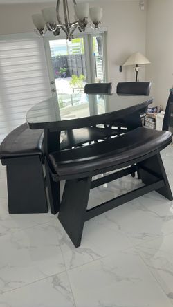 Sofa, chairs, tables, dining tables with stools and bench, and buffet table that hold wine bottles and doors for storage