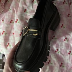 black loafers with gold buckle