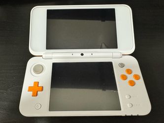 Orange and white 2DS XL with case holder, charger, and 3 games