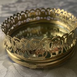 vintage oval vanity mirror tray featuring a gold-toned filigree edge, commonly used to display perfume bottles or hold jewelry