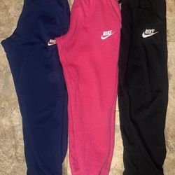 3 pairs of Nike big kid Joggers size large in hot pink, blue, and black 