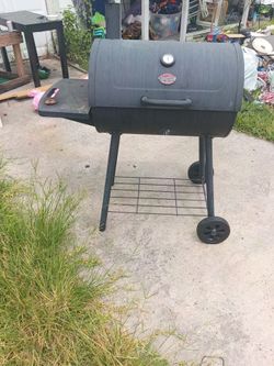 1 brand new bbq pit and 1 bbq pit with a smoker on the side