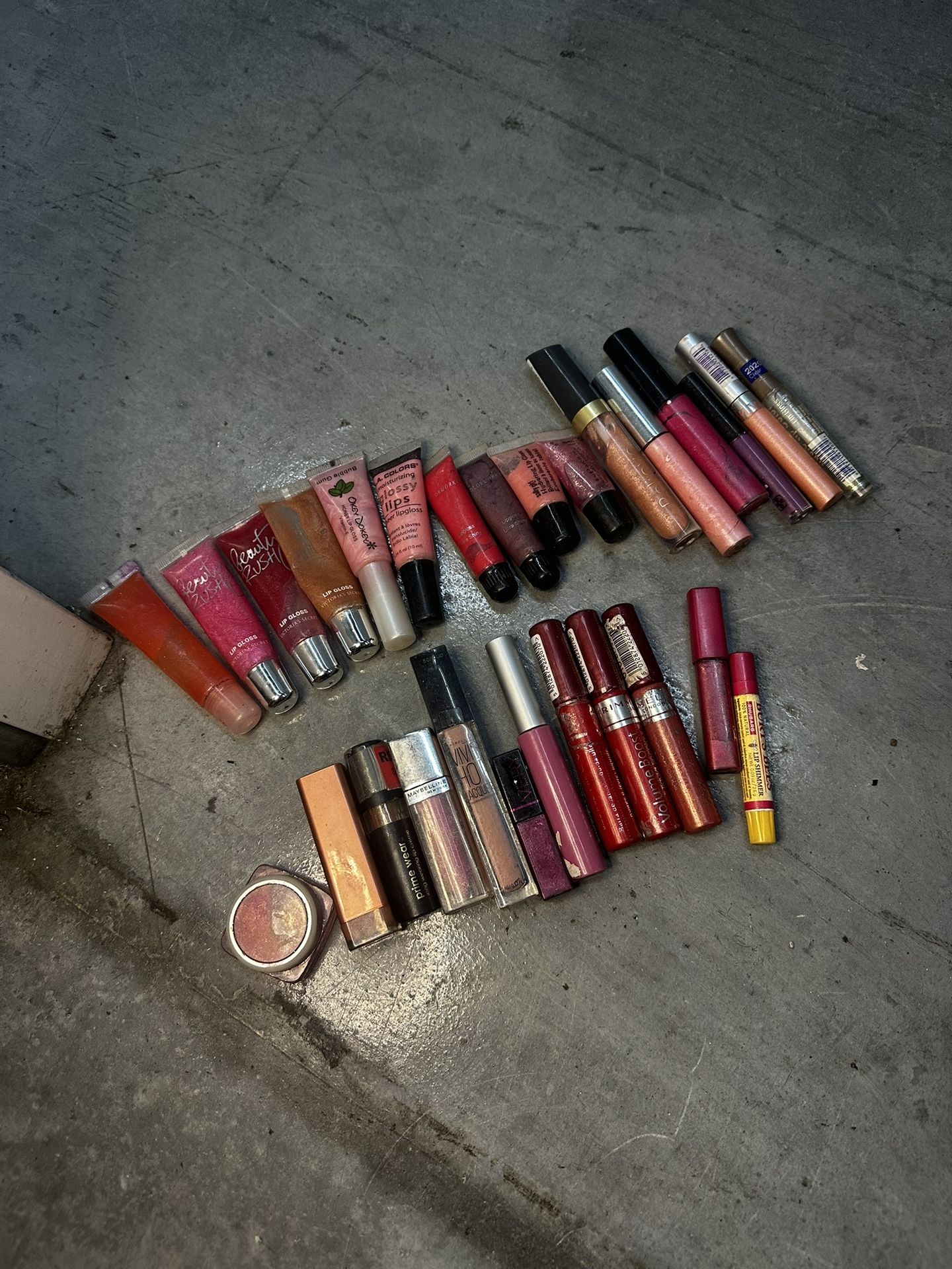 Variety of lip glosses and lipsticks in different shades. Some are used some are new