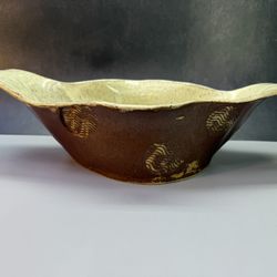Handcrafted oval serving bowl, stoneware pottery, with a distinctive "Cream Rust Glaze" that highlights its textured surface.  Material and Constructi