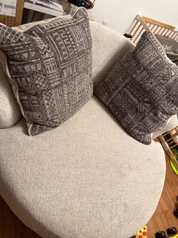 Swivel love seat with throw pillows