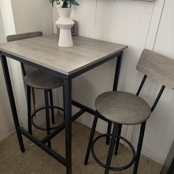 small bar-height dining table with 2 stools