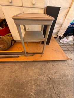 This is a small vintage-style plant table with a lower shelf. It measures approximately 28 inches high by 16 inches wide by 16 inches deep.