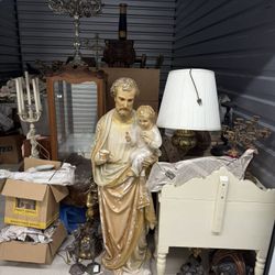 A large, vintage plaster statue of Saint Joseph holding the infant Jesus.