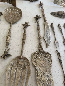 31 pieces vintage Italian flatware set. set includes various utensils such as a serving fork, spoon, tongs, and a knife commonly adorned cherubs made 