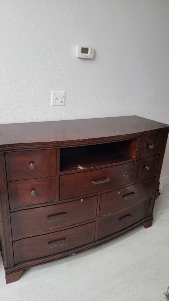 cherry wood dresser with a mix of knob and bar pull hardware. 