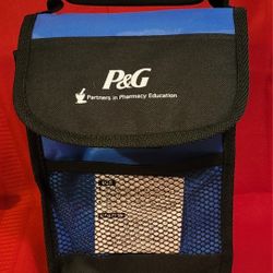 P&G (Procter & Gamble) insulated lunch bag/cooler. The bag has a handle and a mesh side pocket. 7"w×10"h×4"deep