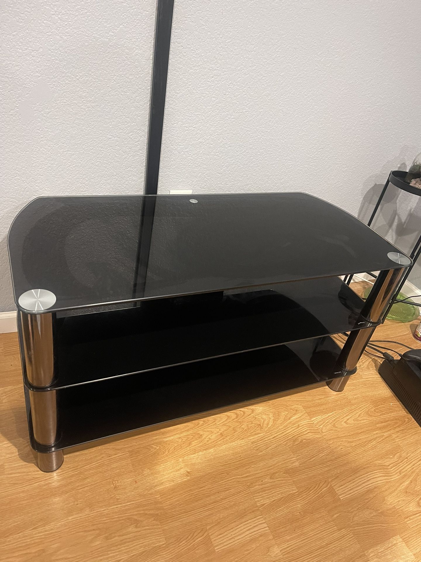 Steel and Glass TV Stand with a black tempered glass chrome-effect legs. Entertainment center