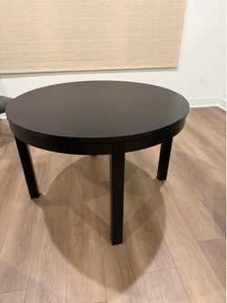 Black circular table with drop leaf extension mechanism