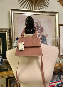 This mini crossbody bag with a top handle and nude crocodile texture is a trendy fashion accessory. Its structured silhouette with a front flap is ins