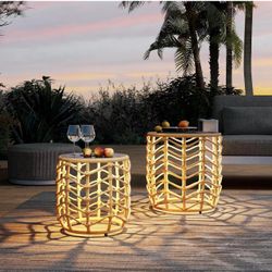 Set of 2 wicker side tables with solar lights. The metal frames are slightly bent, as shown in the photos. Sold as-is.
