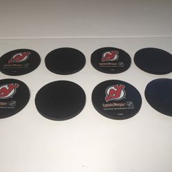 NEW JERSEY DEVILS - Captain Morgan Hockey Puck coasters Set of 8- NHL Licensed These Coasters are formed by cutting a puck into four pieces.  They wer