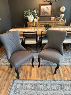 Dark gray upholstered side chairs with black finish cabriole legs.