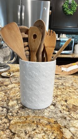 White Ceramic Kitchen Utensil Holder With Wooden Assortment Of Spoons