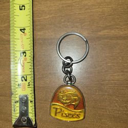 vintage-style Pisces zodiac keychain, likely made of brass with colored enamel detailing.