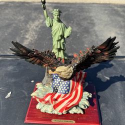 Montefiori Collection figurine, featuring a bald eagle perched atop the Statue of Liberty with an American flag