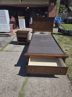 Twin bed frame with drawer that pulls out at the foot of the bed.