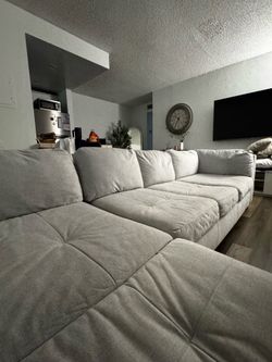 Juego de sala en forma de L color gris.