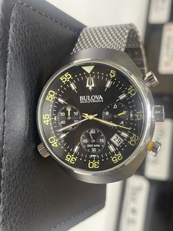 This is a Bulova Accutron II Lobster Chronograph watch with a black dial and a stainless steel mesh bracelet