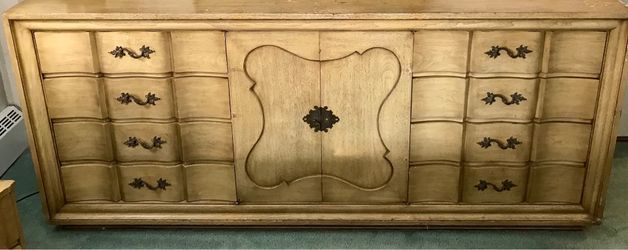 Elegant vintage wooden dressers with ornate handles.