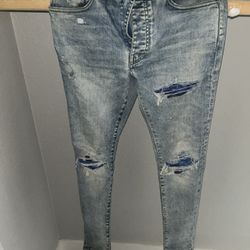 Amiri Distressed Skinny Jeans – Light Wash Blue Patch Repair Denim”