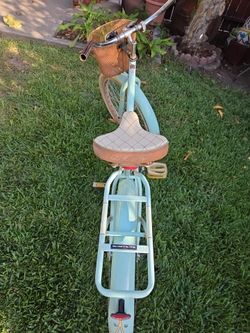 Huffy light blue and brown cruiser bike with basket and rack