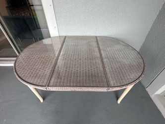 Wicker patio dining table with glass