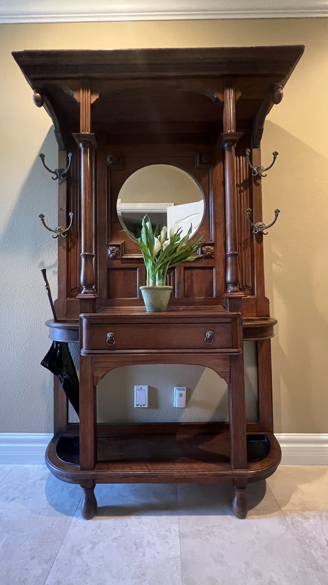 Antique Hall Tree Stand with 4 Coat/Hat Hooks, Umbrella Drip Tray & Beveled Mirror The center has one drawer a perfect place to set your keys. It is