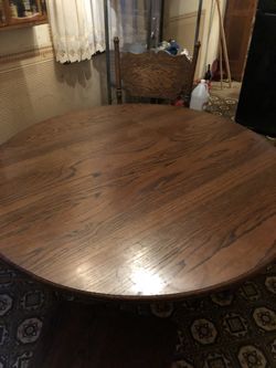 Solid oak four foot round dining table with two foot leaf extends to six foot oval table with gears for ease of removing and placing leaf.