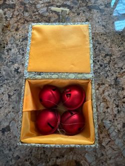This set consists of four red metal bells in a decorative Chinese brocade box.