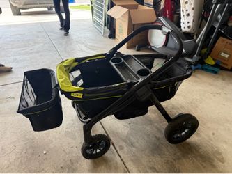 Evenflo Pivot Xplore stroller wagon features a black frame with lime green accents and all-terrain wheels